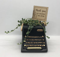 Baby black typewriter planter by Allen Designs. Pictured planted with string of pearls succulent and a timber plant tag by Bibbidi Bub which reads 'Thank you for helping me grow.' The perfect teacher's gift!