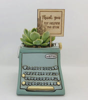 Allen Designs Baby Blue Typewriter Planter. Pictured planted with an Echeveria succulent and a sign which reads 'Thank you for helping me grow' by Melbourne maker Bibbidi Bub