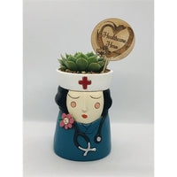 Baby Healthcare Hero Planter with Black Hair by Allen Designs. Pictured planted with a succulent and displayed with a healthcare hero timber plant tag