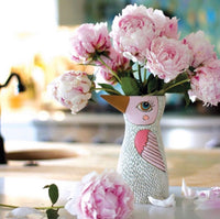 White bird vase or watering can by Allen Designs. Pictured in a kitchen holding light pink roses