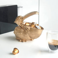 Gold Peter the Pelican Bowl by White Moose. Pictured holding coffee pods in his beak