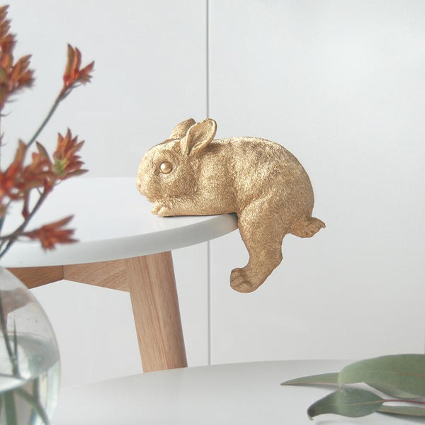 Gold Shelf Bunny by White Moose. Pictured hanging off a coffee table